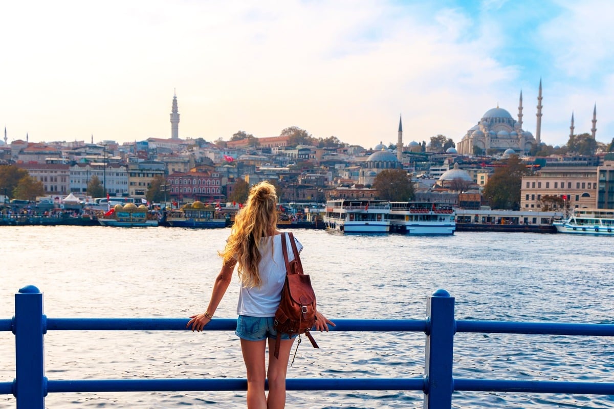 Young Woman Admiring A View Of The Historical Peninsula Of Istanbul From Galata Bridge, Istanbul, Turkiye Or Turkey Western Asia, Eastern Europe.jpg